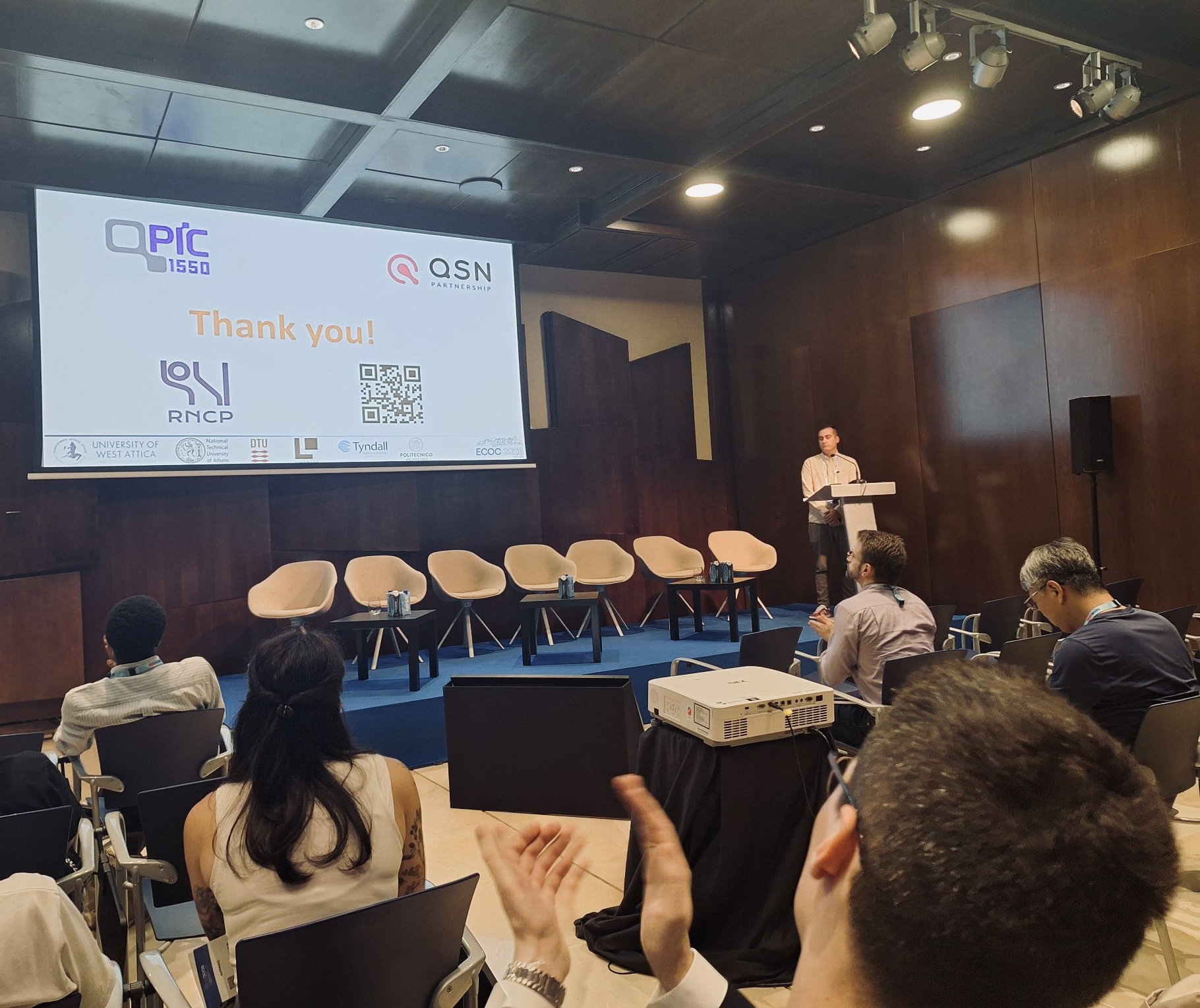 Dr. Kostas Sozos stands on stage while delivering a contributed talk.